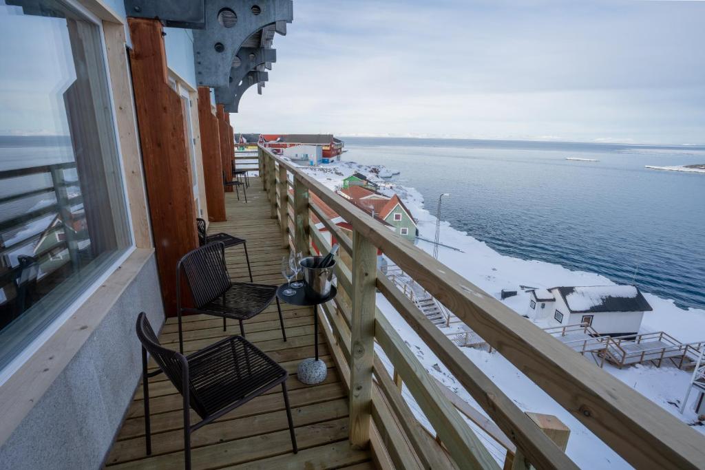 a balcony of a ship with chairs and the water at Hotel Hvide Falk in Ilulissat
