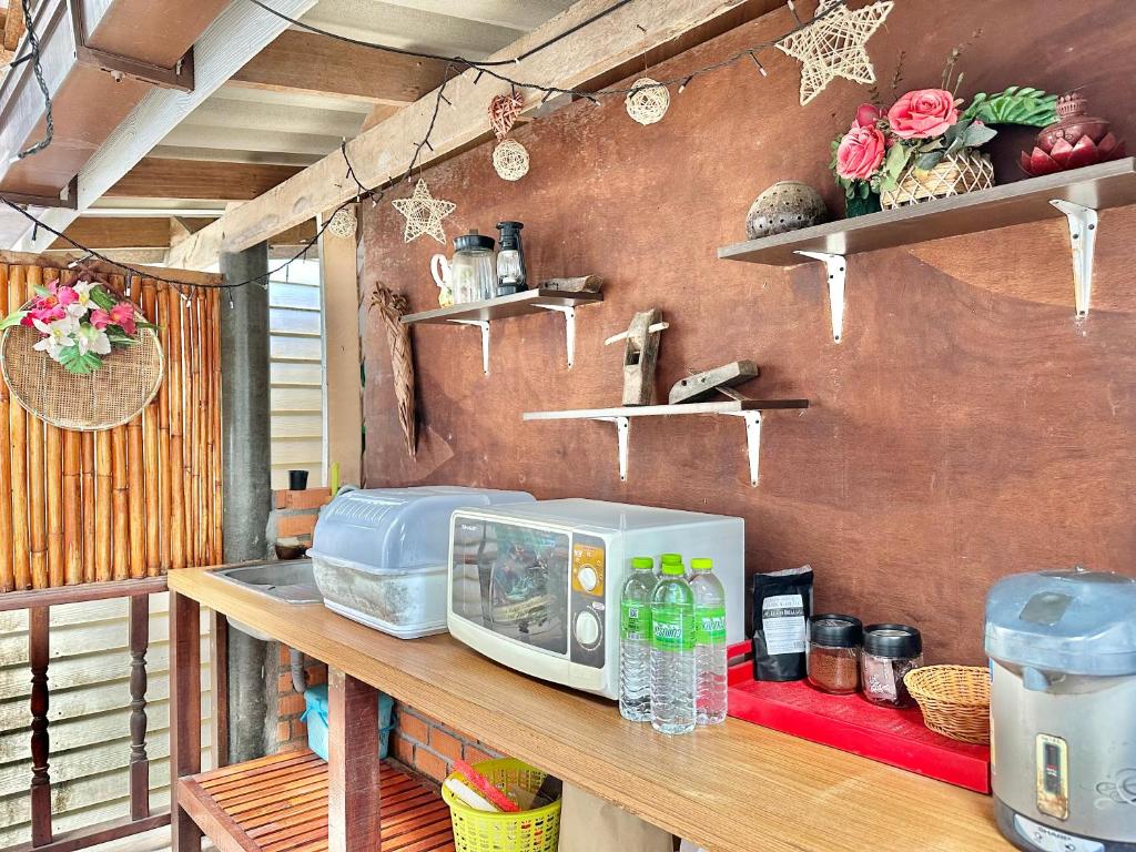 a counter with a microwave on top of a table at Lanta Sabai Day House in Ko Lanta