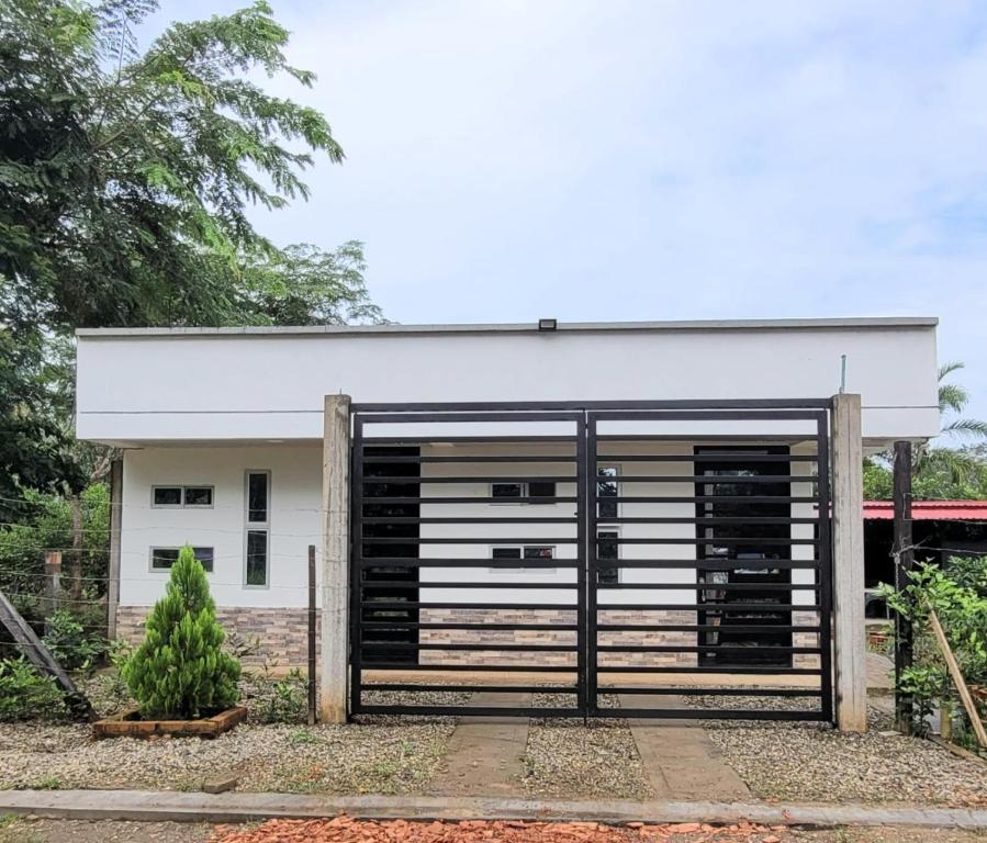 uma garagem com portas pretas e um edifício branco em Casa Campestre Villa Maria em San José del Guaviare