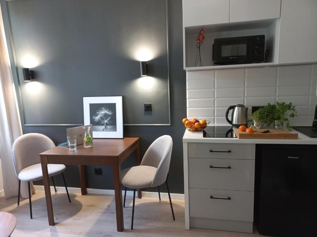 a kitchen with a table and a table and chairs at Przytulne studio przy Atlas Arena i malowniczym parku in Łódź