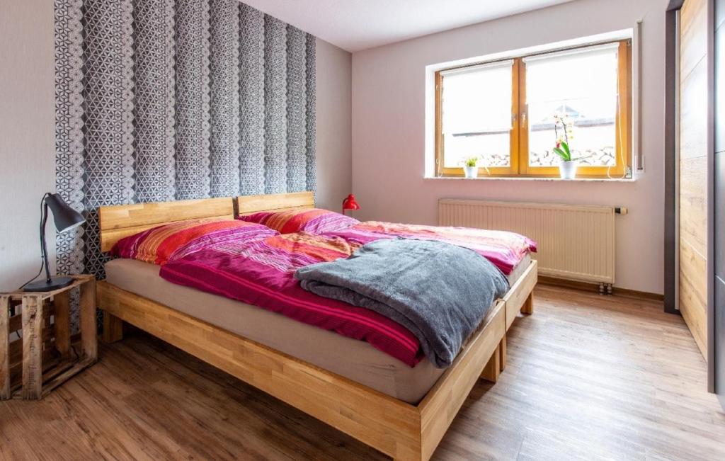 a bedroom with a bed and a window at Ferienwohnung Franz Erlabrunn in Erlabrunn