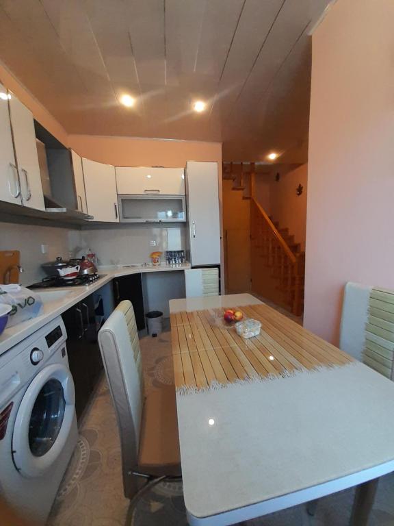 a kitchen with a table and a washing machine at 2-storey apartment in Mardakan