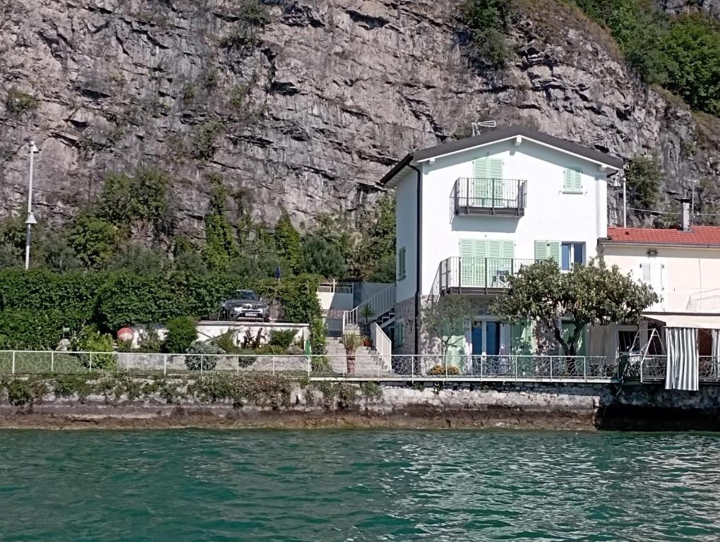 a white house on the side of a cliff at La Casina a Remi in Marone