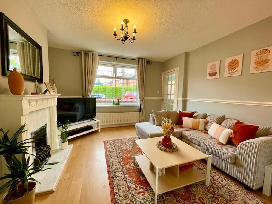 Cosy Croft Cottage في Greasbrough: غرفة معيشة مع أريكة ومدفأة