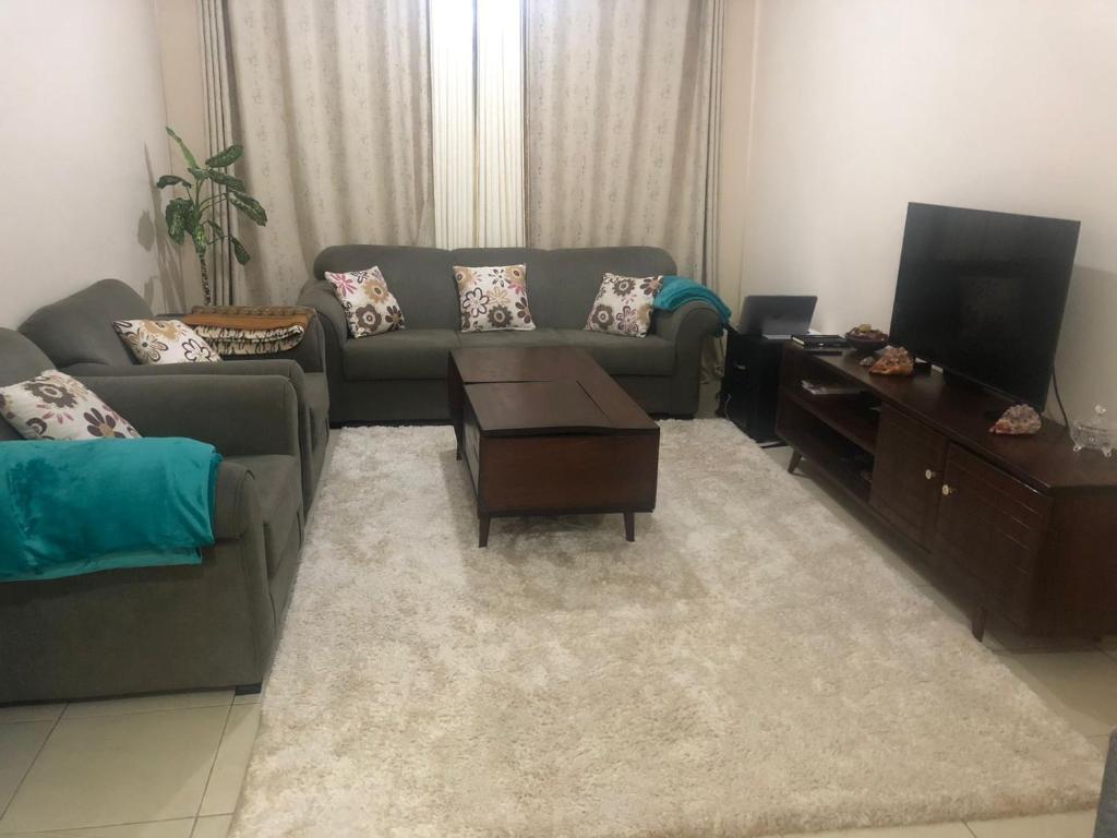 a living room with a couch and a tv at PASWELL'S HOMES 3 Bedroom Apartment at Greatwall Gardens in Athi River