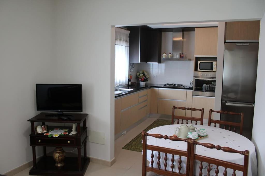 a small kitchen with a table and a television at Charming Religious House II in Fátima