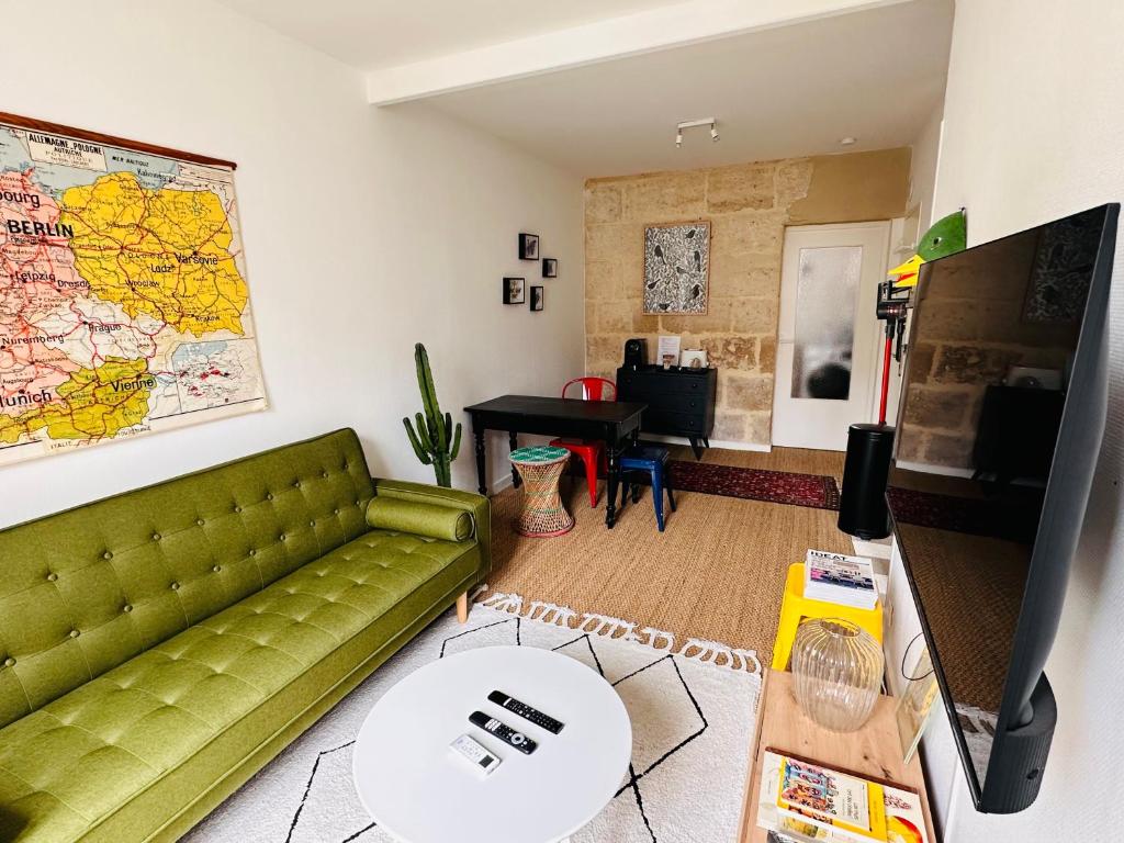 - un salon avec un canapé vert et une table dans l'établissement Appartement cosy, Duck, Secteur Boinot - wifi, netflix, prime vidéo, à Niort