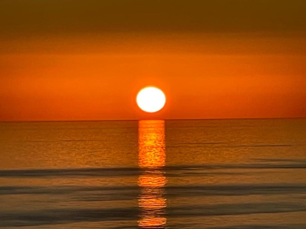 un tramonto sull'oceano con il tramonto di Orizzonte senza Fine a Marina di Palma