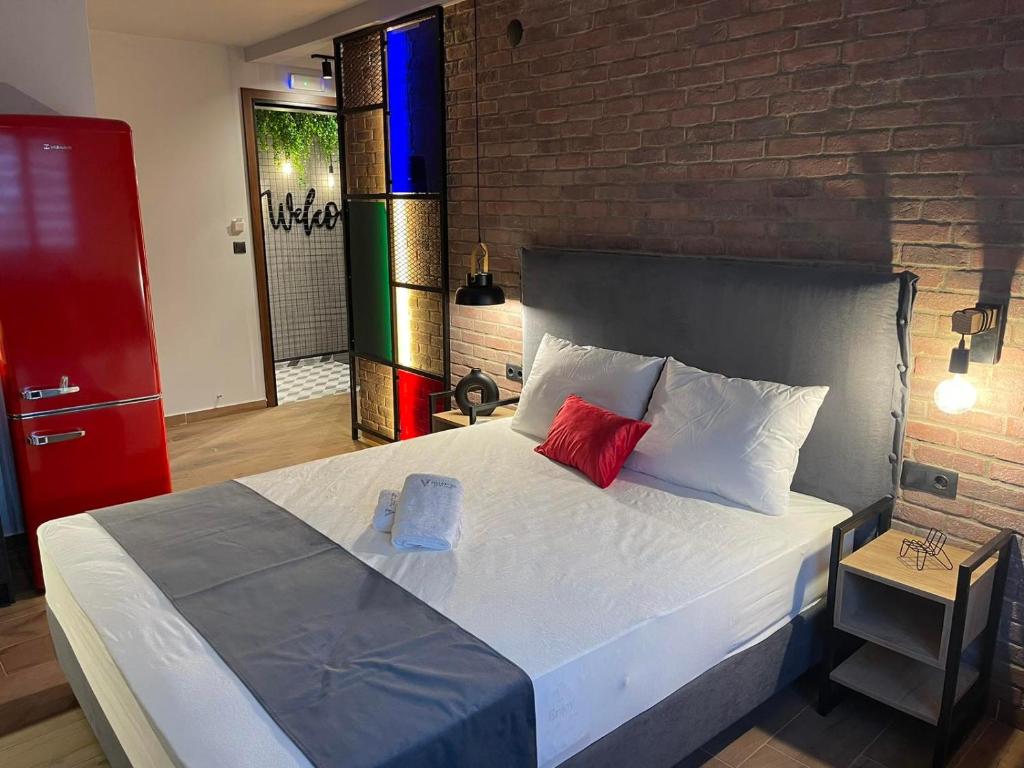 a bedroom with a large bed with a brick wall at Valaoritou 3 Luxury Rooms in Thessaloniki