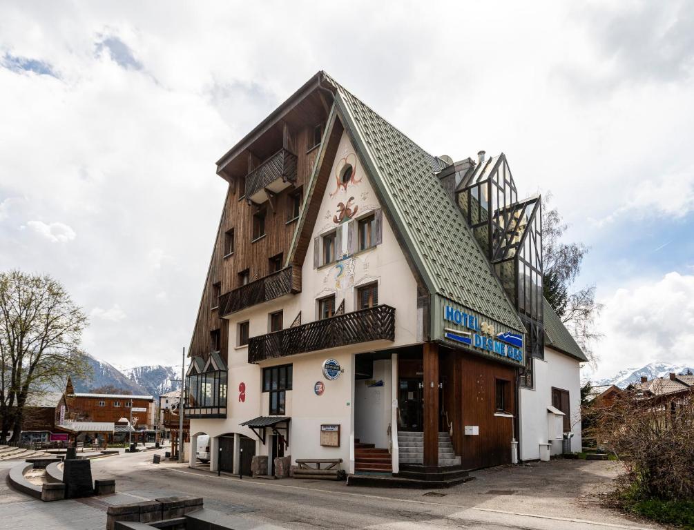 un bâtiment avec un toit en gambrel dans une rue dans l'établissement HOTEL DES NEIGES, à Les Deux Alpes