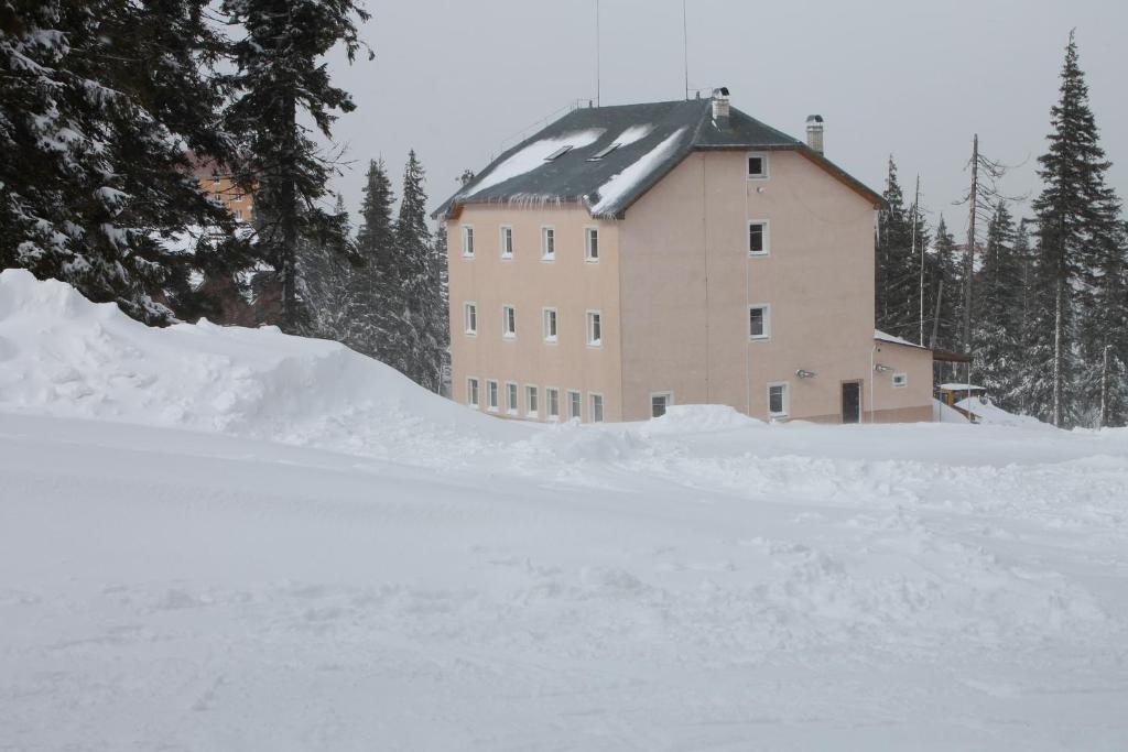 un bâtiment avec une pile de neige devant lui dans l'établissement Оаза, à Dragobrat
