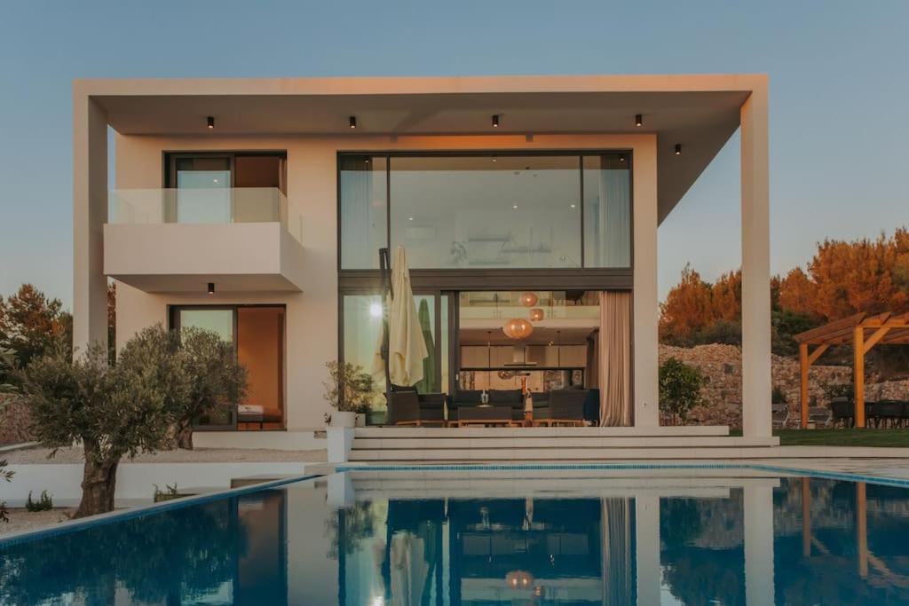 a house with a swimming pool in front of a house at Villa Maris - Luxury Villa with Pool in Brodarica