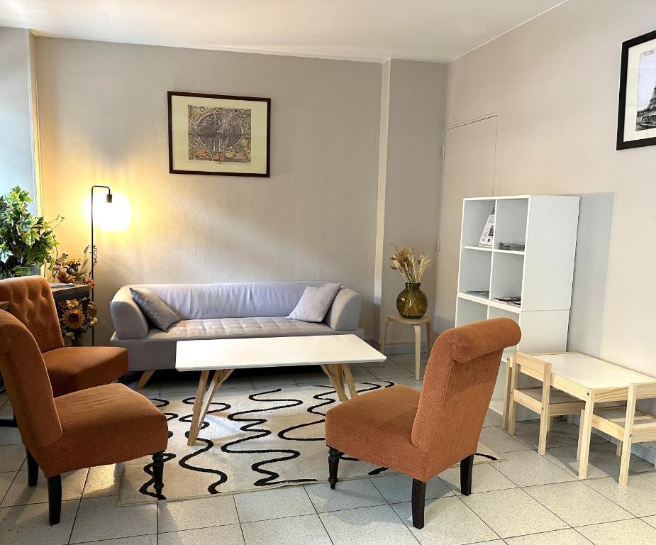 - un salon avec un canapé et deux chaises dans l'établissement Timhotel Boulogne Rives de Seine, à Boulogne-Billancourt