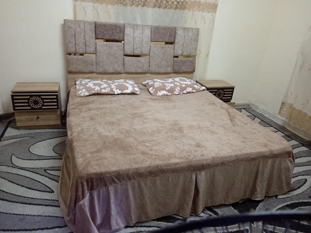 a bedroom with a large bed with two pillows on it at Marmr in Abū Turābah