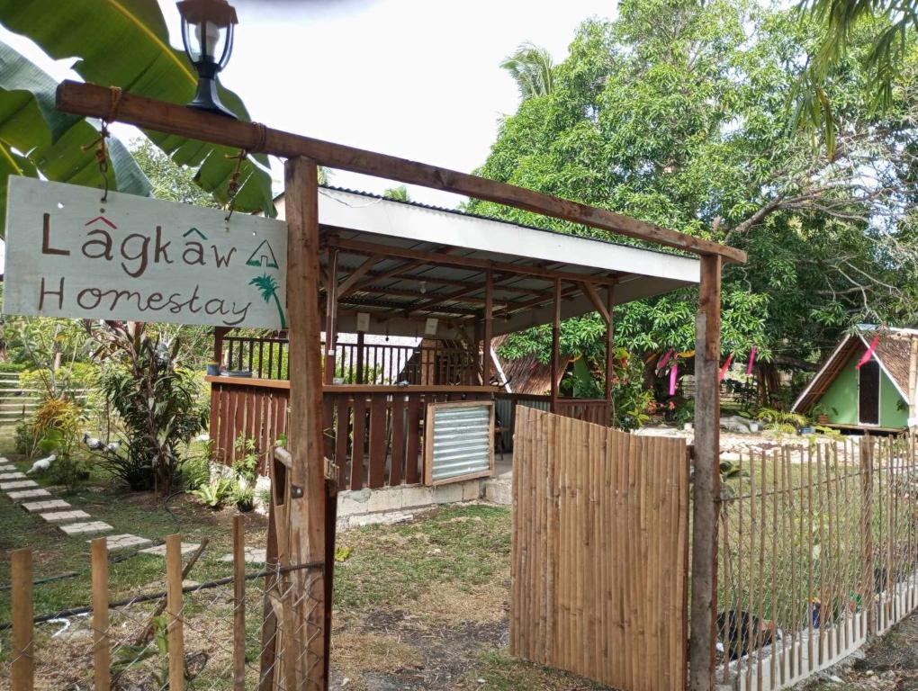 un cancello in legno con un cartello e una recinzione di Lagkaw Uno in Lagkaw Homestay a Panglao