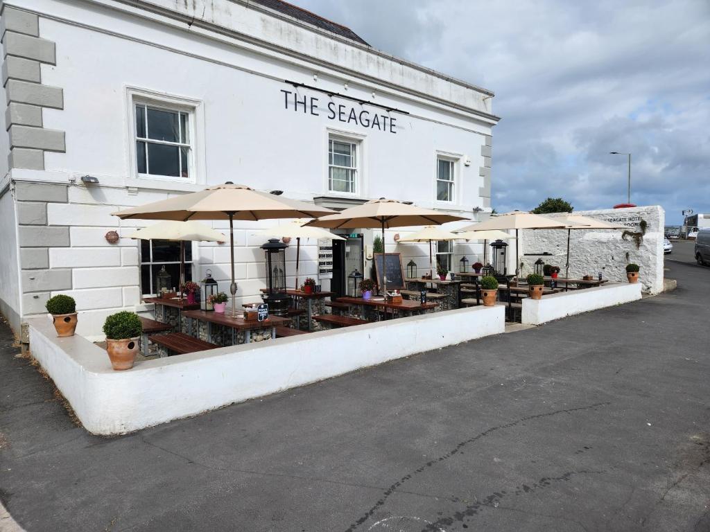 a white building with tables and umbrellas on it at The Seagate in Appledore