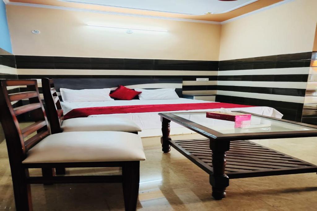 Super OYO Riverview Resort And Restaurant في Jhājhar: غرفة نوم بسرير وطاولة وكرسي