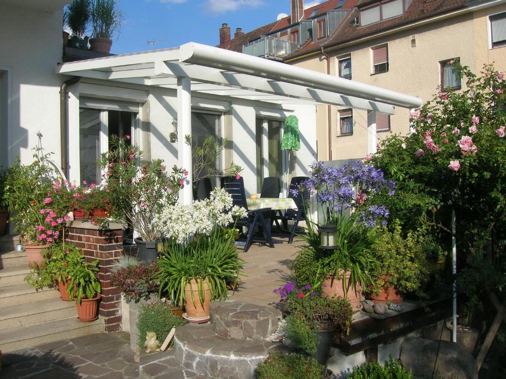 a white pergola on a house with flowers and plants at Ferienwohnung Andrea Kühlein in Zirndorf