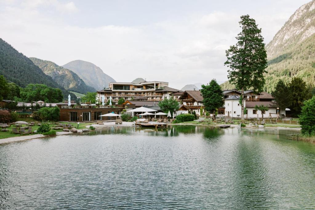 a resort with a lake and mountains in the background at POST Family Resort in Unken