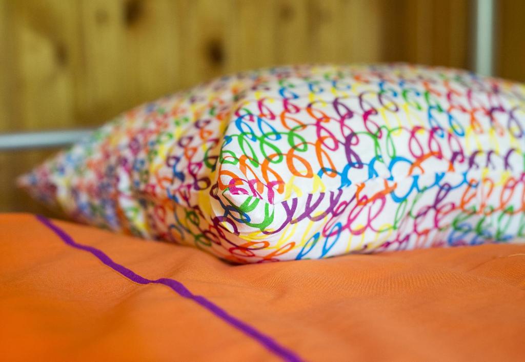 a colorful pillow sitting on top of a bed at Green Jurmala Hostel in Jūrmala