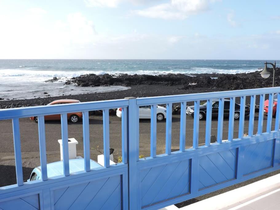 a blue gate on a balcony looking at the beach at Casa Leyna in El Golfo