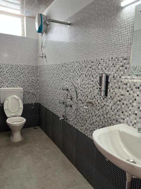 un bagno con doccia, WC e lavandino di J.J bed and breakfast a Port Blair