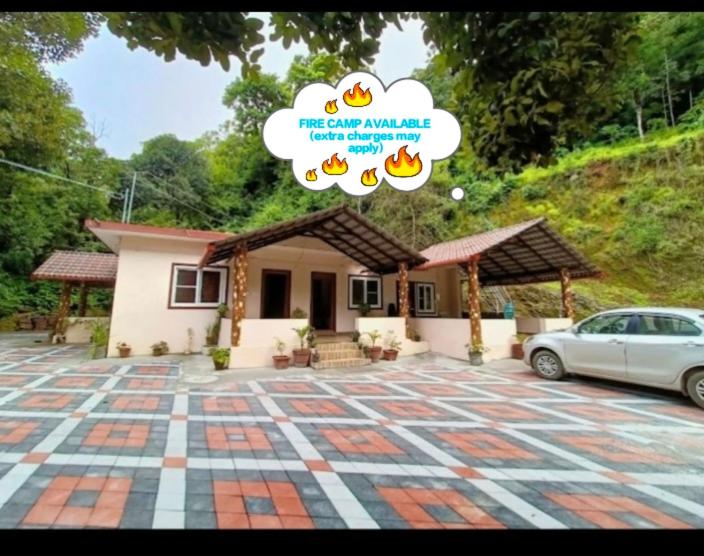 a small house with a car parked in front of it at KATAKERI HOLIDAY HOME in Madikeri