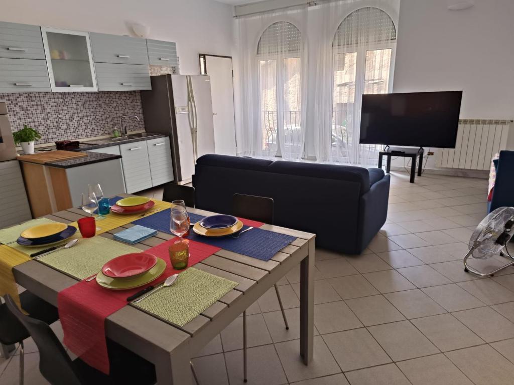 kuchnia i salon ze stołem i kanapą w obiekcie KuneKune MONOLOCALE w mieście Albissola Marina