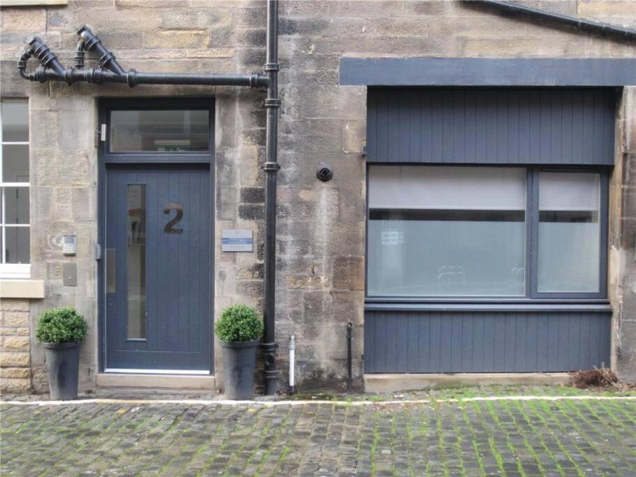 a house with a blue door and two windows at Stylish City Apartment in Edinburgh