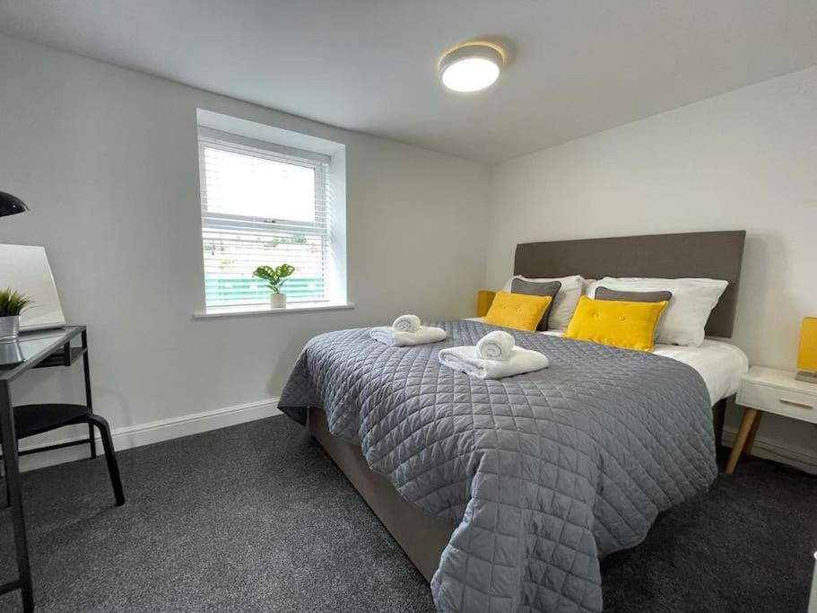 a bedroom with a bed with two towels on it at Flat 1 High Street Apartments, One Bed in Wellington