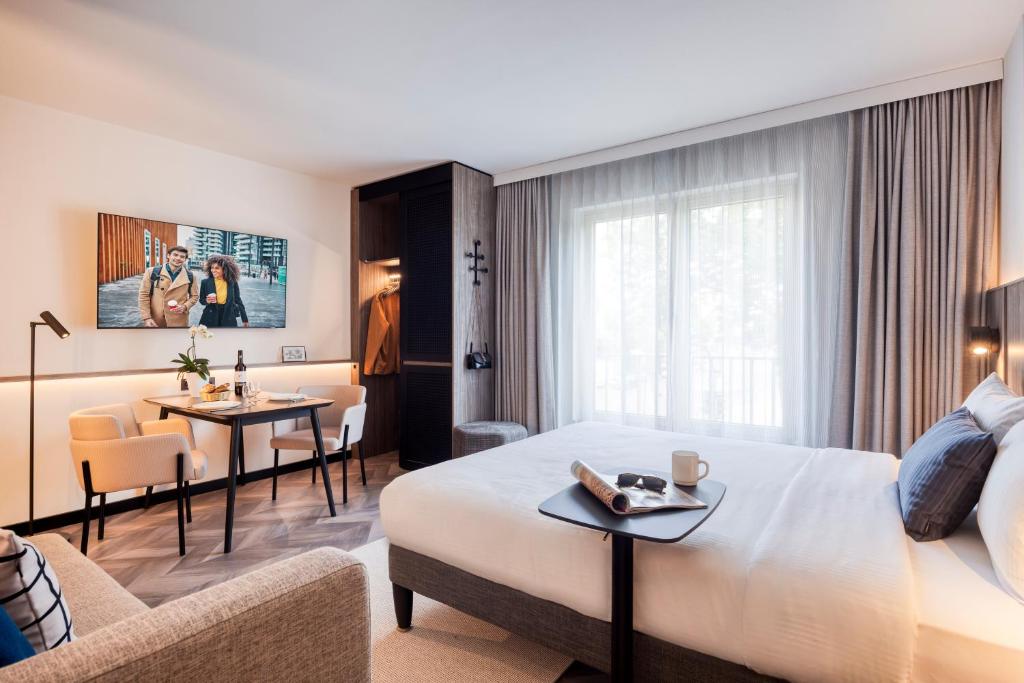 ベルリンにあるCitadines Kurfürstendamm Berlinのベッドとリビングルームが備わるホテルルームです。
