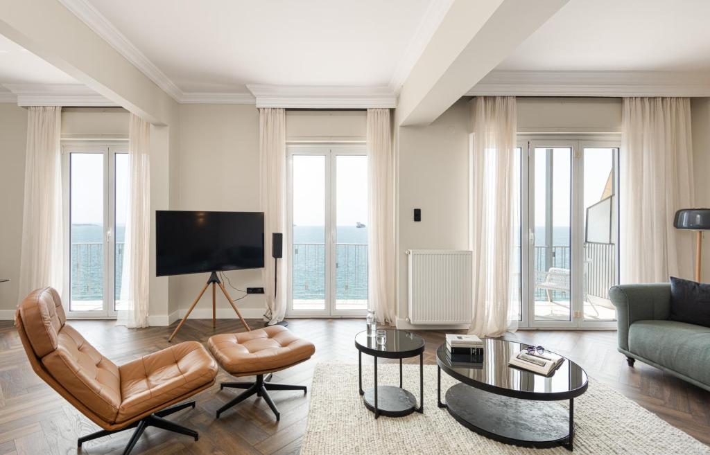 een woonkamer met een bank en een tv bij Primavera Seafront apt by halu! next to White Tower in Thessaloniki