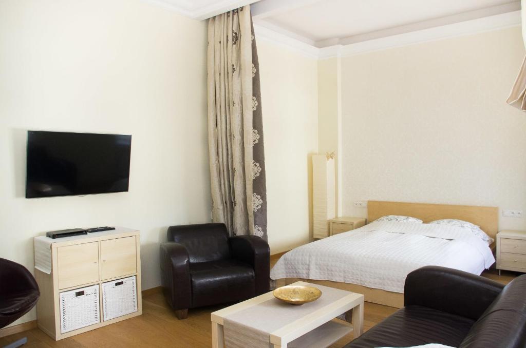 een woonkamer met een bed en een stoel bij Apartamenty Królowej in Sopot