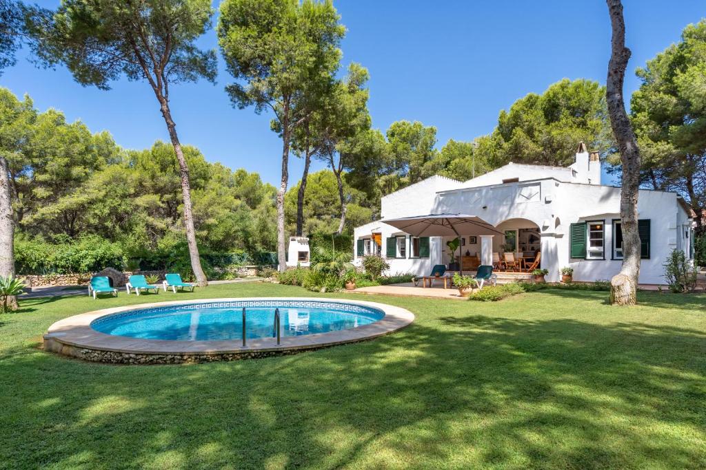 a house with a swimming pool in a yard at N'Antiga in Sant Lluis