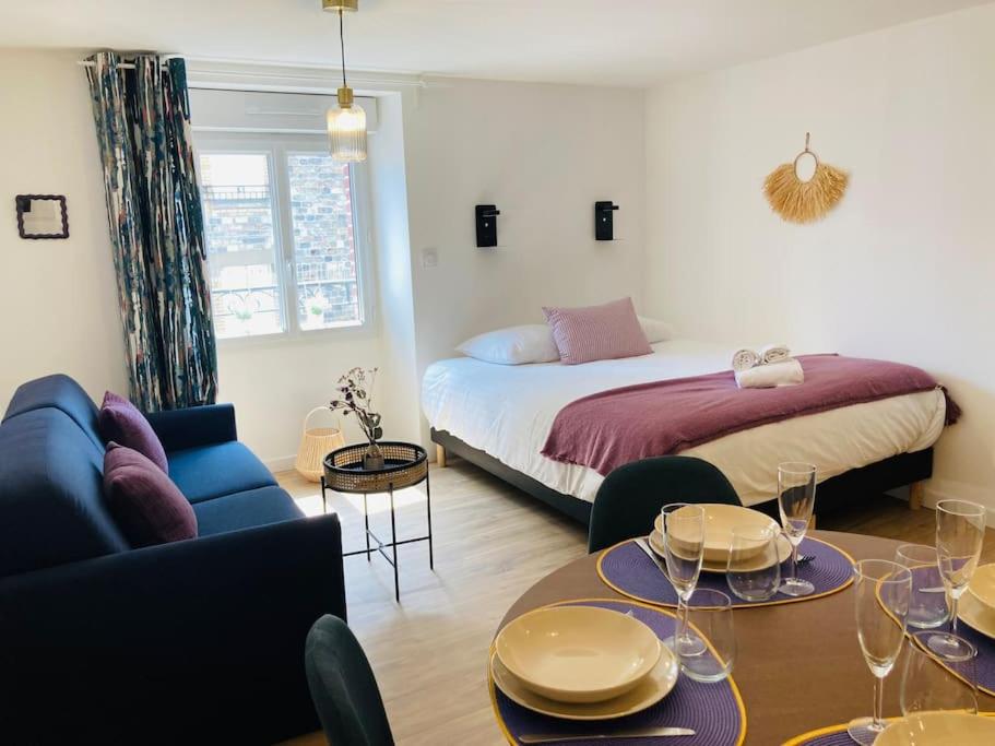 Cette chambre comprend un lit et une table avec des verres. dans l'établissement Le Cattleya, studio cosy à Rennes, à Rennes