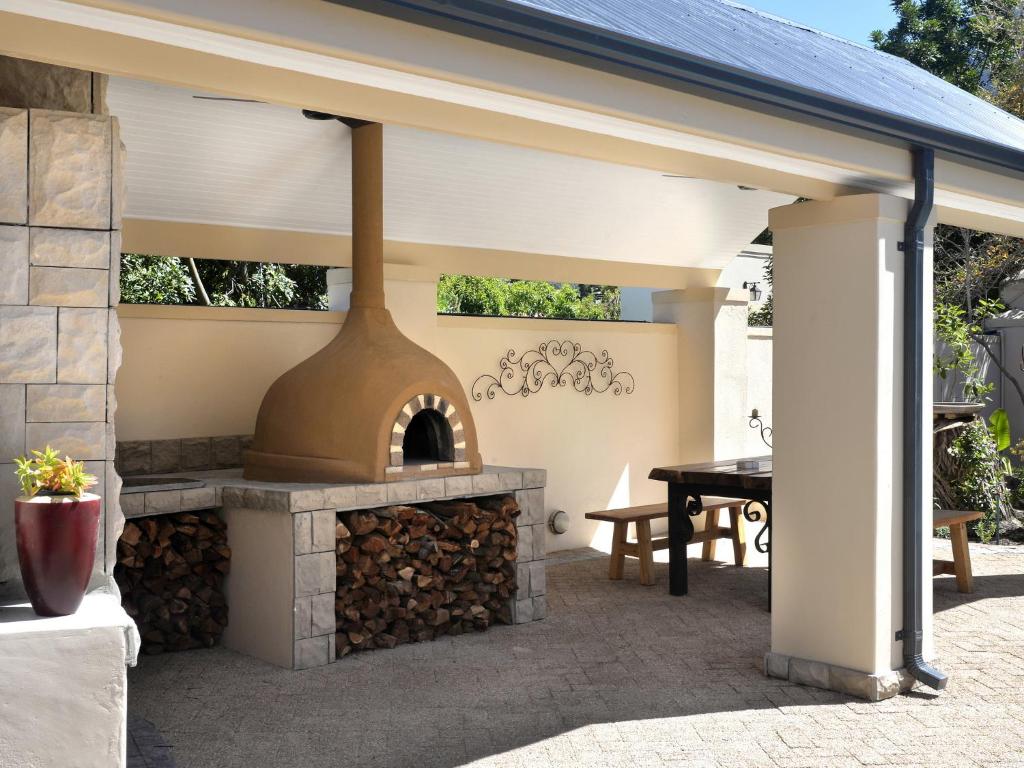 un patio con un horno al aire libre con una mesa en The Protea Apartment no01, en Franschhoek