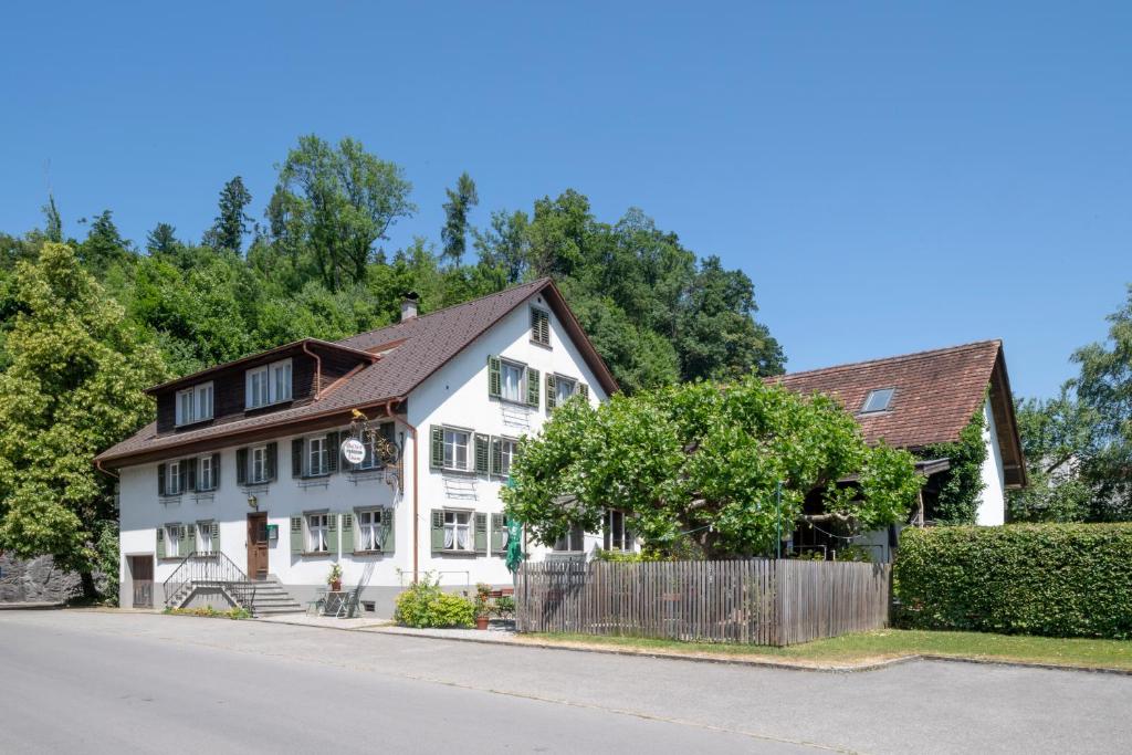 une maison blanche avec un toit marron dans l'établissement Gasthof Löwen Tosters, à Feldkirch