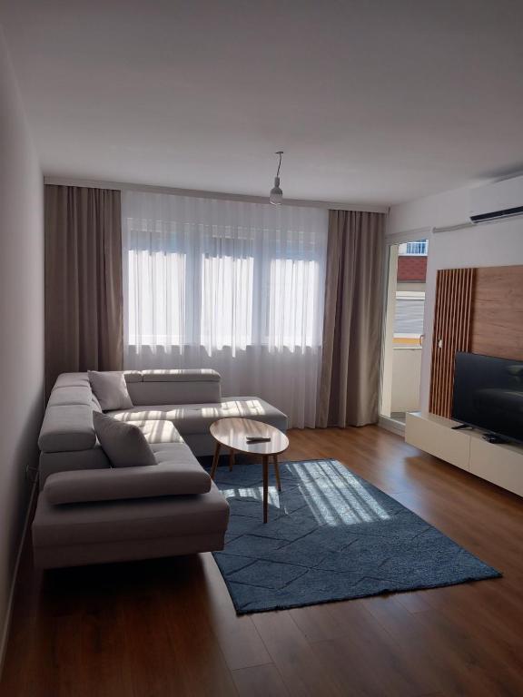 佩奇的住宿－Banesa ne qender te Pejes 2，客厅配有沙发和桌子