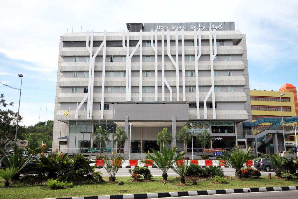 a tall white building with trees in front of it at Badi'ah Hotel in Bandar Seri Begawan