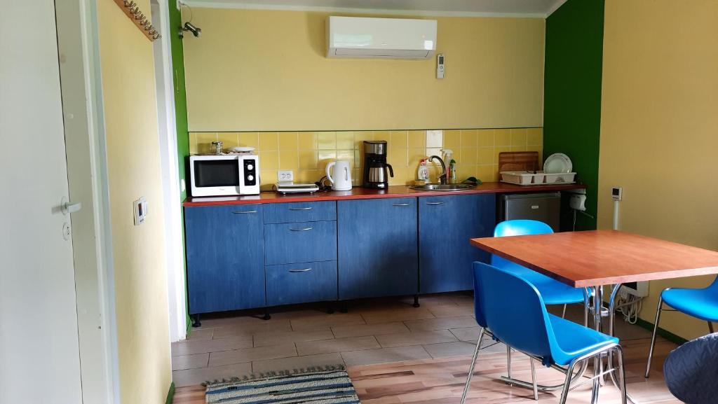 a kitchen with blue cabinets and a table with blue chairs at Willipu peremajad in Pusi