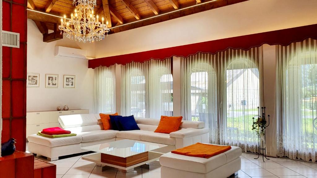 a living room with a white couch and a chandelier at Luxuriöse Villa Romantica in Gampel