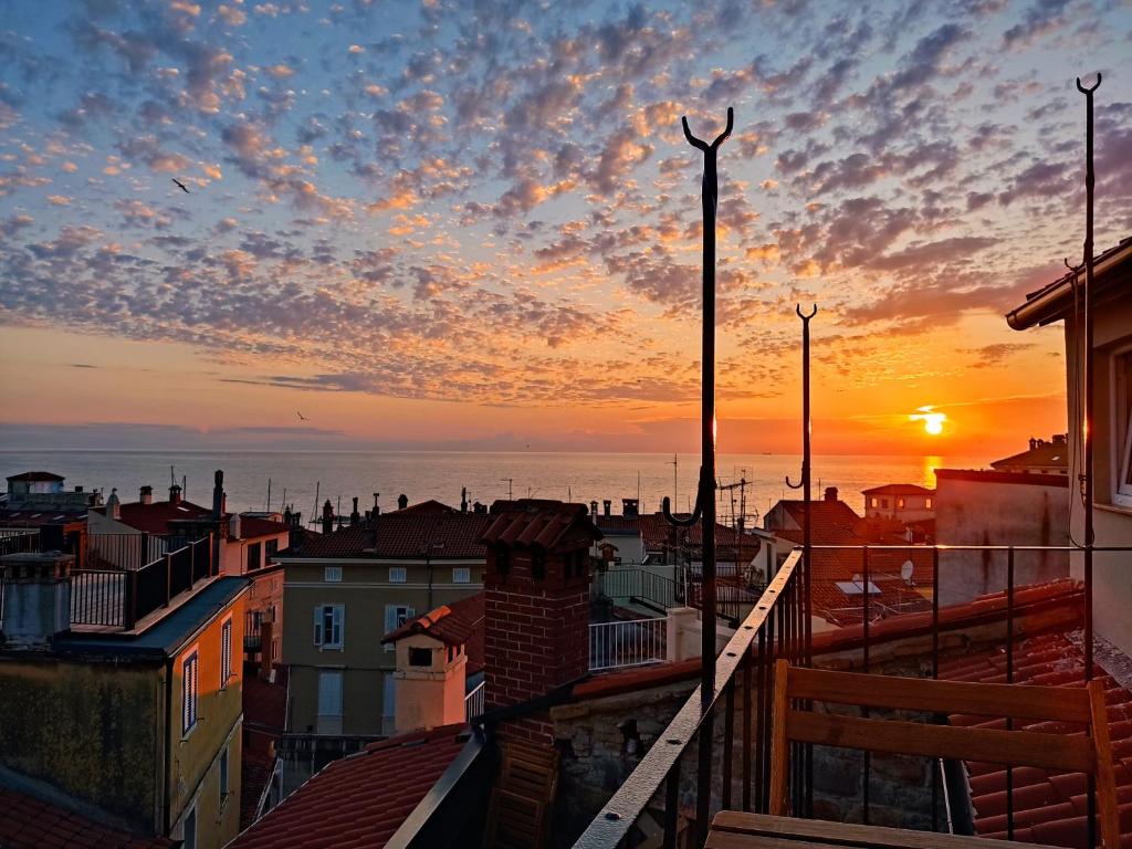 una vista sul tramonto da un balcone di una città di Via Paradiso Apartments a Piran