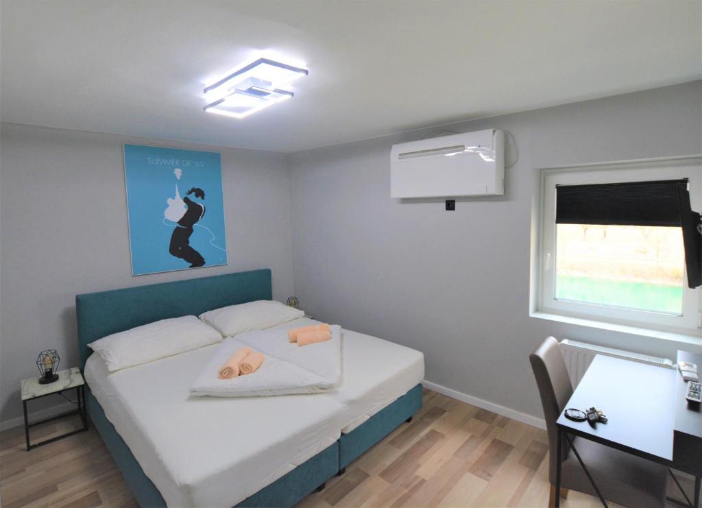 1 dormitorio con cama, mesa y ventana en Stadthotel Das Villach en Villach