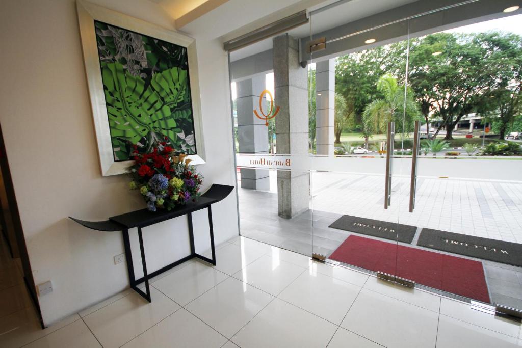 a lobby with a table with a vase of flowers on it at Badi'ah Hotel in Bandar Seri Begawan