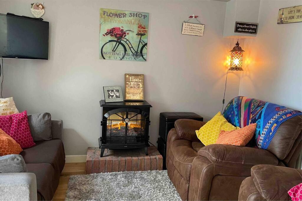 a living room with a couch and a fire place at Sea Breeze Cottage Mulranny in Mulranny