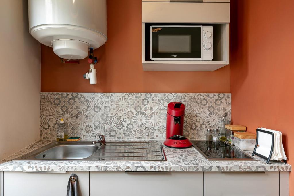 a kitchen with a sink and a microwave at Perpignan - Appartement en centre ville in Perpignan