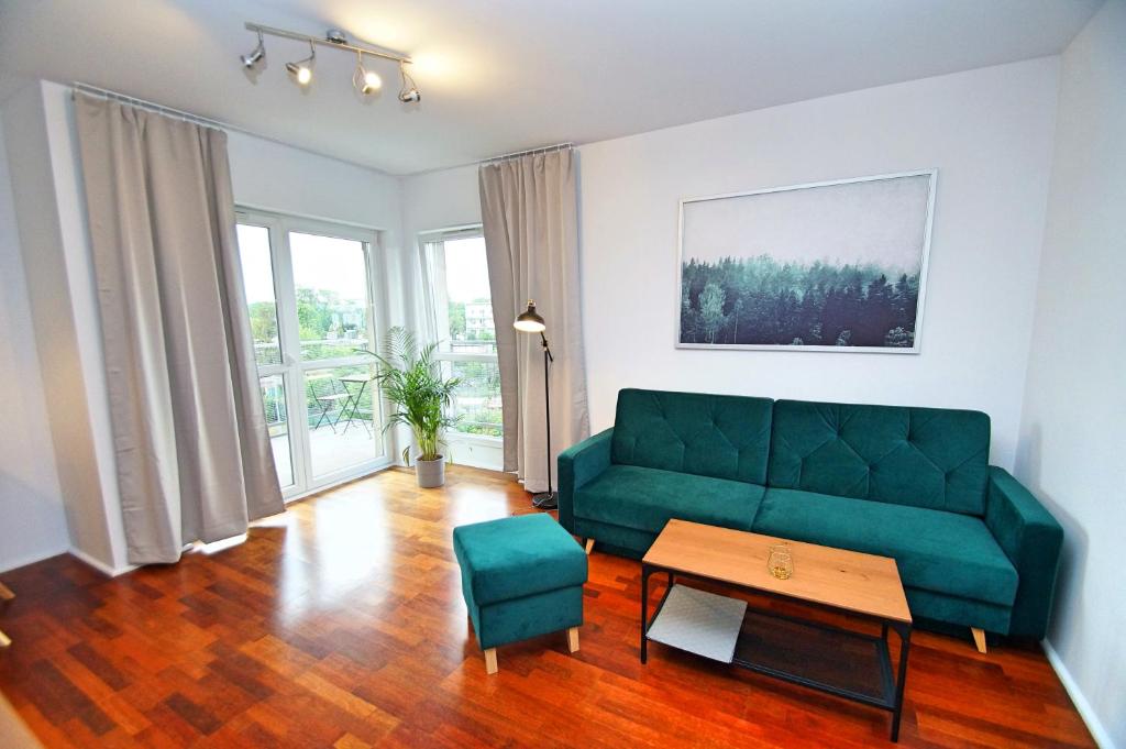 een woonkamer met een groene bank en een tafel bij Katowice, Johna Baildona, City Center in Katowice