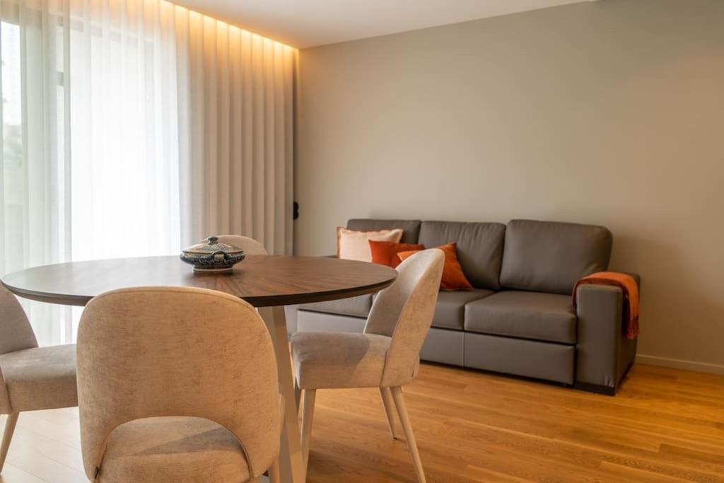 een woonkamer met een tafel en een bank bij Luisa Beach Studio in Estoril