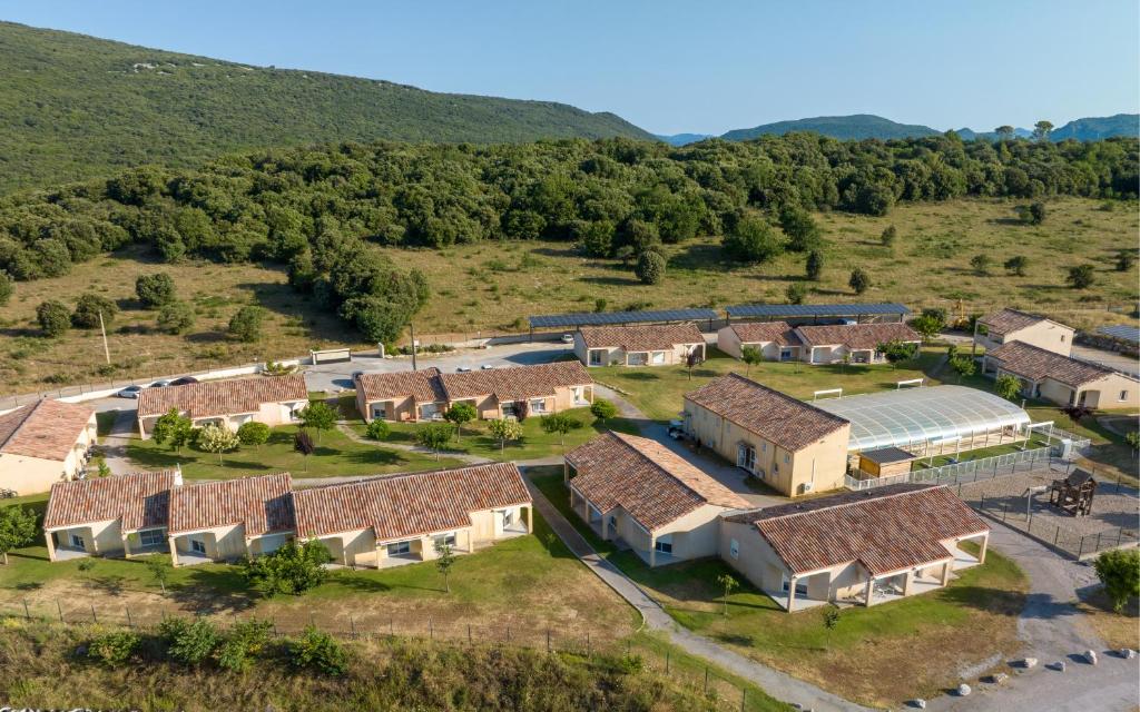 eine Luftansicht eines Betriebs mit einer Gruppe von Häusern in der Unterkunft Park & Suites Village Gorges de l'Hérault-Cévennes in Brissac