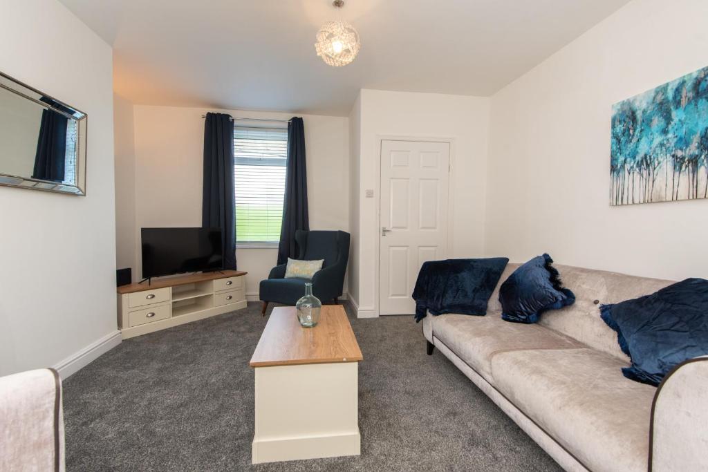 a living room with a couch and a tv at Richardson Place in Kirk Merrington